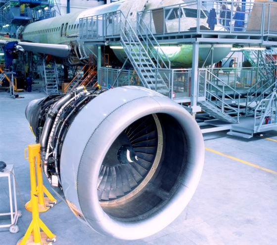 A large jet engine sitting on top of an airport runway.